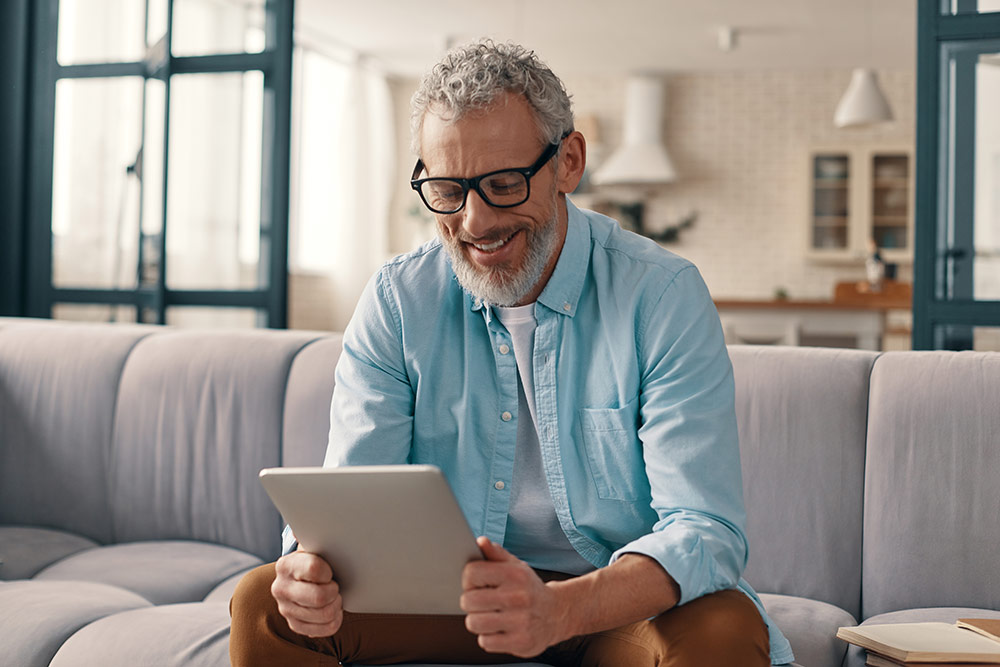 Foto Newsletter – Ein älterer Herr an einem iPad